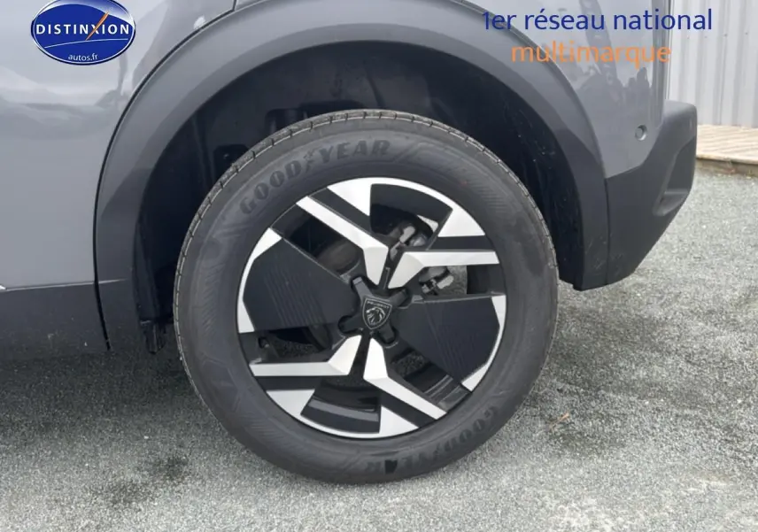 Gros plan sur la roue avant droite du Peugeot 2008 gris sélénite avec jante alu au design moderne.