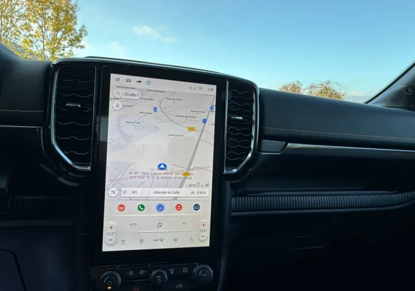 Vue intérieure du tableau de bord du Ford Ranger PHEV 281 Wildtrak avec écran tactile central et finition noire.