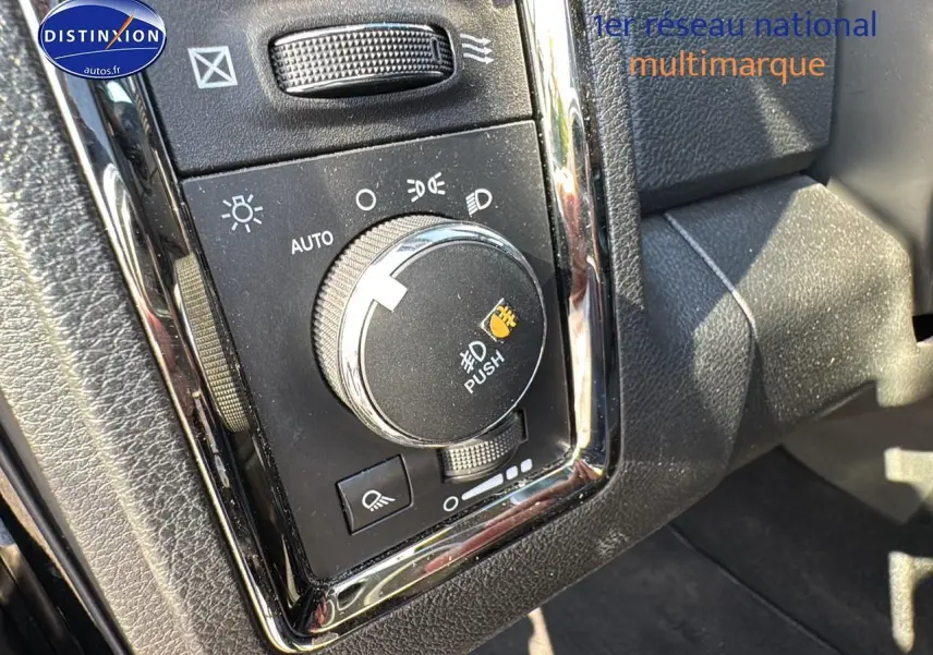 Gros plan sur le bouton de commande des phares du Dodge RAM 5.7 V8 noir, intérieur avec finitions chromées.