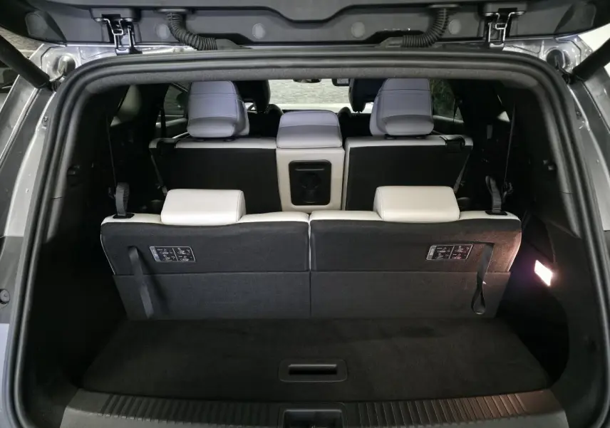 Coffre ouvert vu de l'arrière du Renault Espace gris, montrant la banquette arrière en sellerie textile claire.