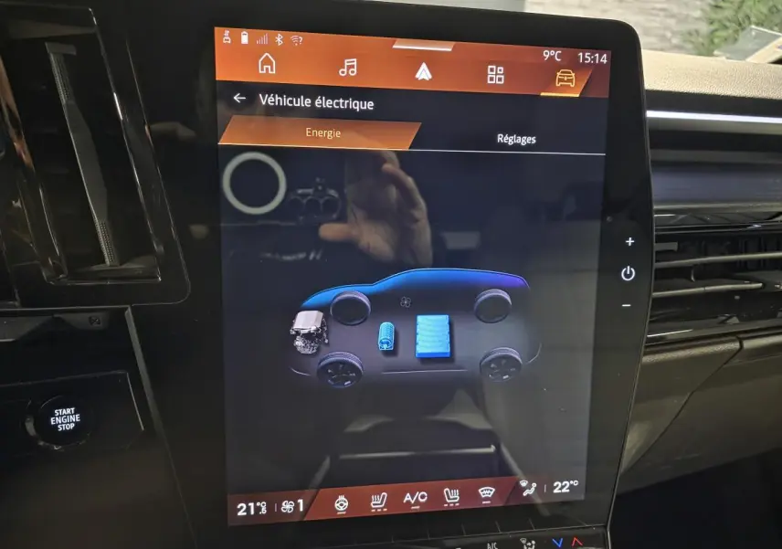 Écran tactile central du tableau de bord du Renault Espace gris, affichant l'énergie du véhicule hybride en vue schématique.