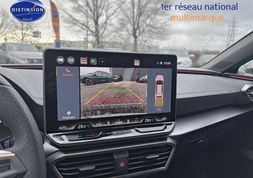 Vue intérieure du tableau de bord de la CUPRA Leon ST gris magnétique avec écran tactile affichant la caméra de recul.