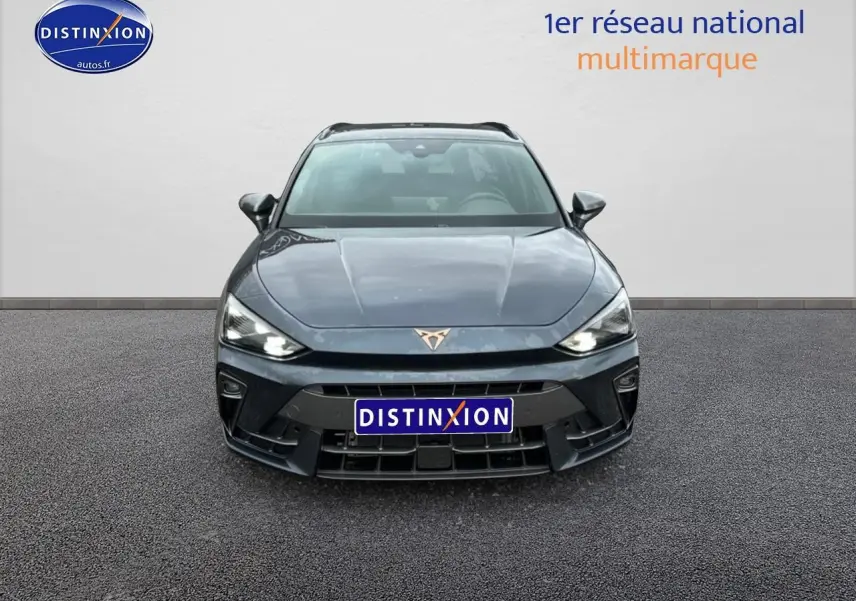 Vue frontale d'une CUPRA Leon ST 1.5 etsi hybrid gris magnétique avec phares LED allumés sur fond neutre.