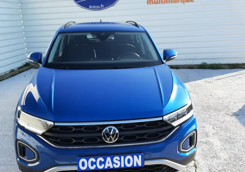 Vue avant d'un Volkswagen T-Roc bleu 2022 avec calandre noire et plaque "OCCASION" visible.