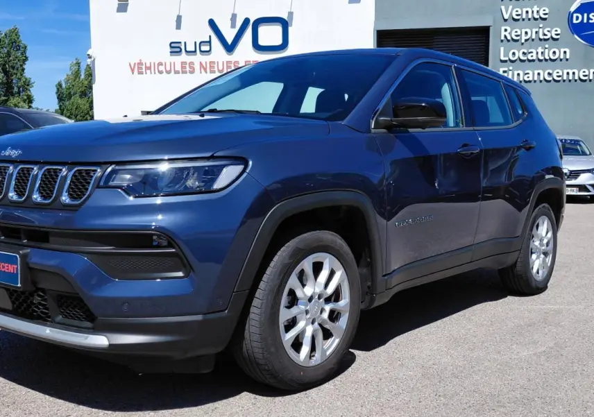 Jeep Compass bleu en 3/4 avant droit, avec calandre distinctive et jantes alliage 18 pouces visibles.