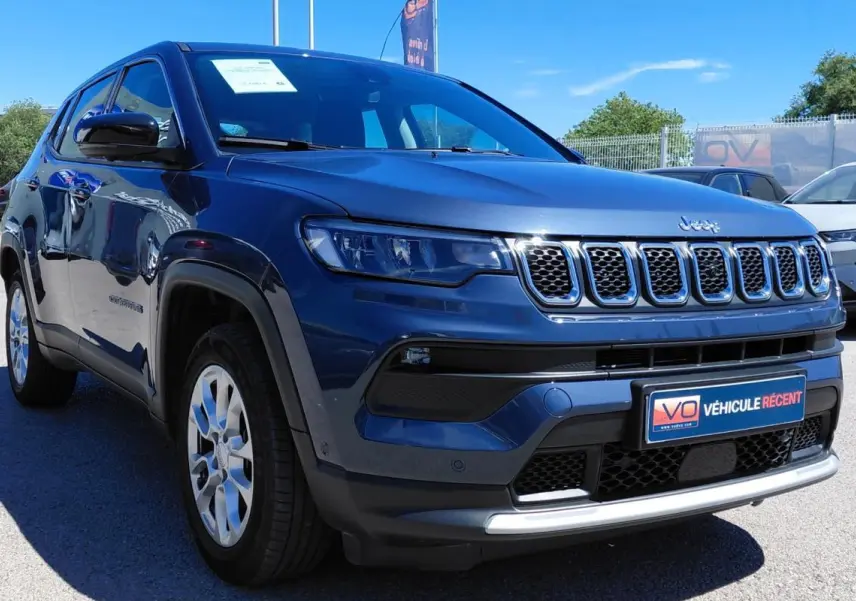 Jeep Compass bleu en 3/4 avant droit, avec calandre distinctive et jantes alliage 18 pouces visibles.