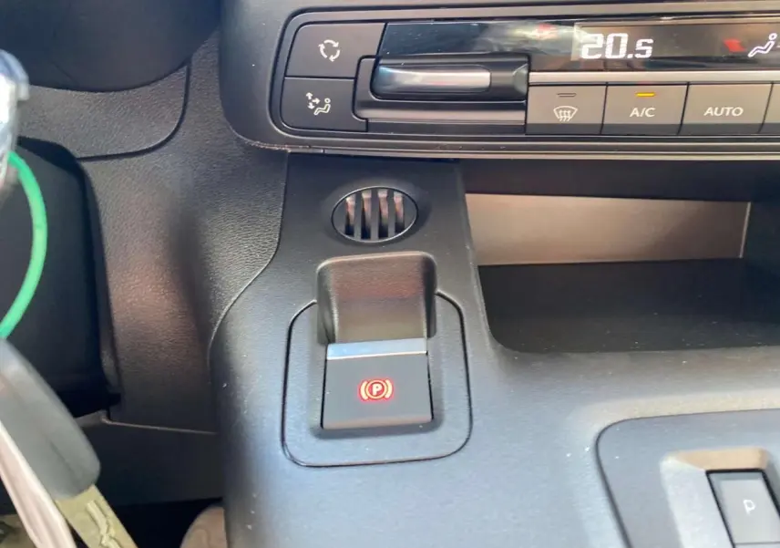 Détail du frein de stationnement électrique et commandes de climatisation du Citroën Berlingo 2026 noir, intérieur avant.