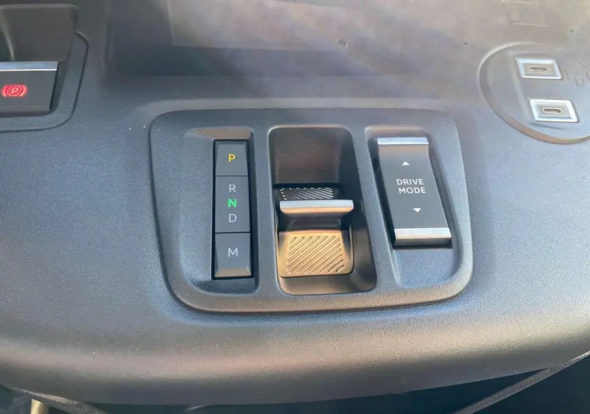 Gros plan sur la console centrale noire du Citroën Berlingo 2026 montrant la commande de boîte automatique et le bouton Drive Mode.