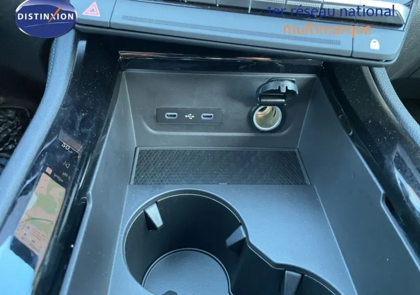 Gros plan sur la console centrale noire du Renault Austral 2026, montrant prises USB, allume-cigare et porte-gobelets.