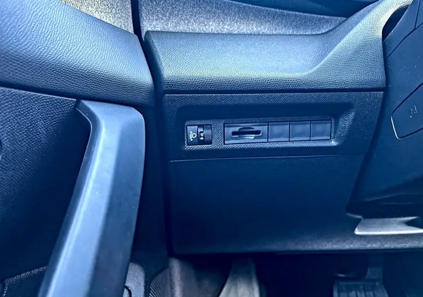 Détail intérieur côté gauche avec commandes d’éclairage sur tableau de bord noir de Peugeot 308 2025.