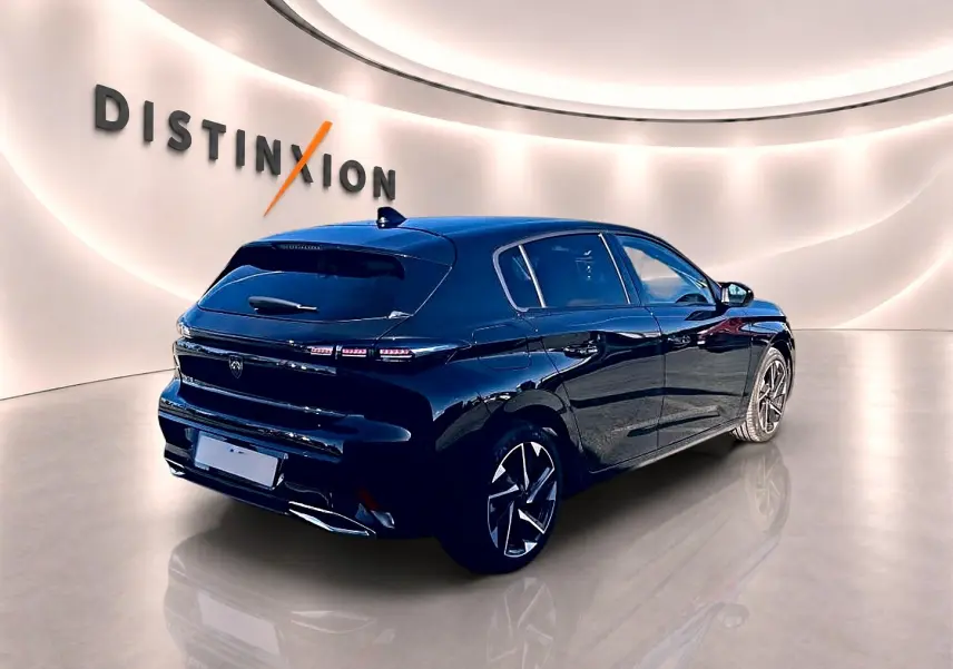 Peugeot 308 noire vue en 3/4 arrière droit dans un showroom avec jantes alliage et feux LED distinctifs.