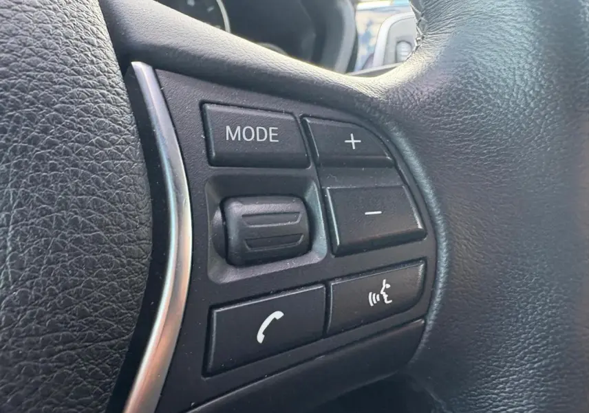 Gros plan sur les commandes multifonctions en cuir noir du volant de la BMW Série 4 Gran Coupé 420d.