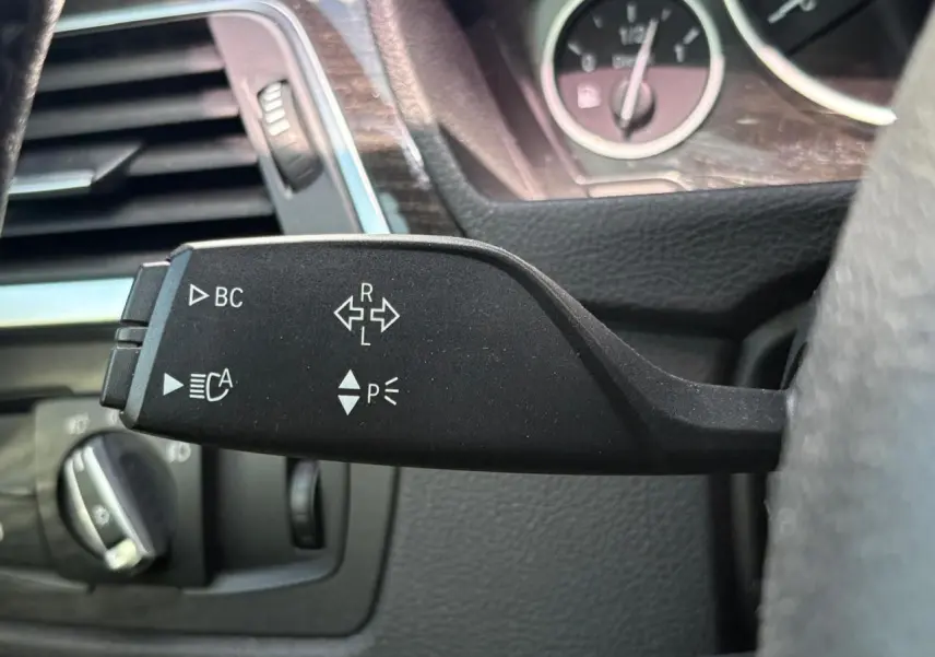 Gros plan sur le commodo gauche noir mat de la BMW Série 4 Gran Coupé 420d, avec commandes d'indicateurs et fonctions assistées.