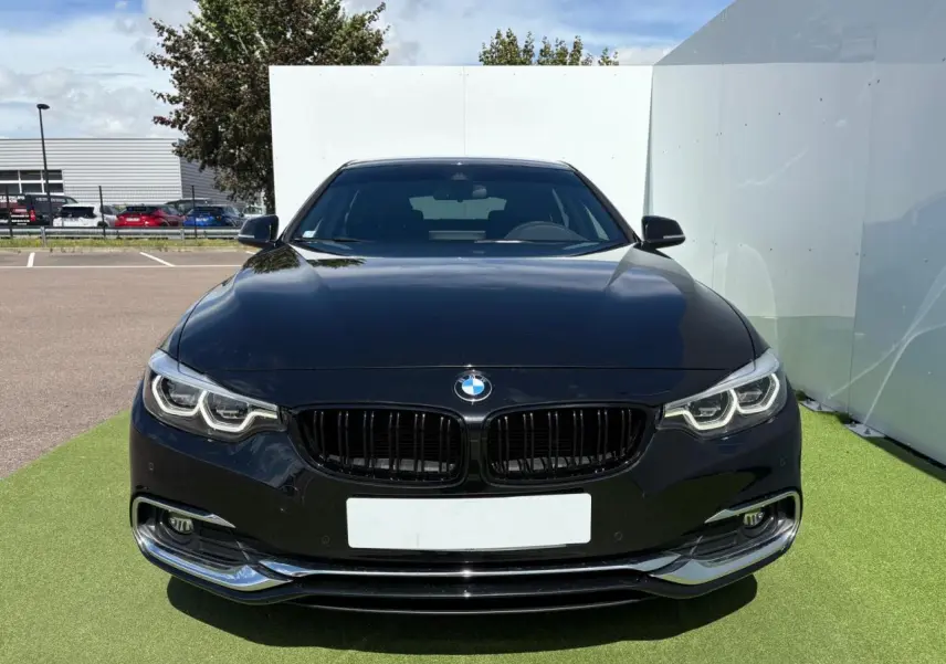 BMW Série 4 Gran Coupé noir saphir vue de face, mettant en valeur ses phares Full LED et calandre noire brillante.