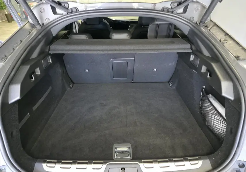 Coffre spacieux vu de l'arrière d'une Peugeot 408 gris, avec banquette arrière et filet de rangement visible.