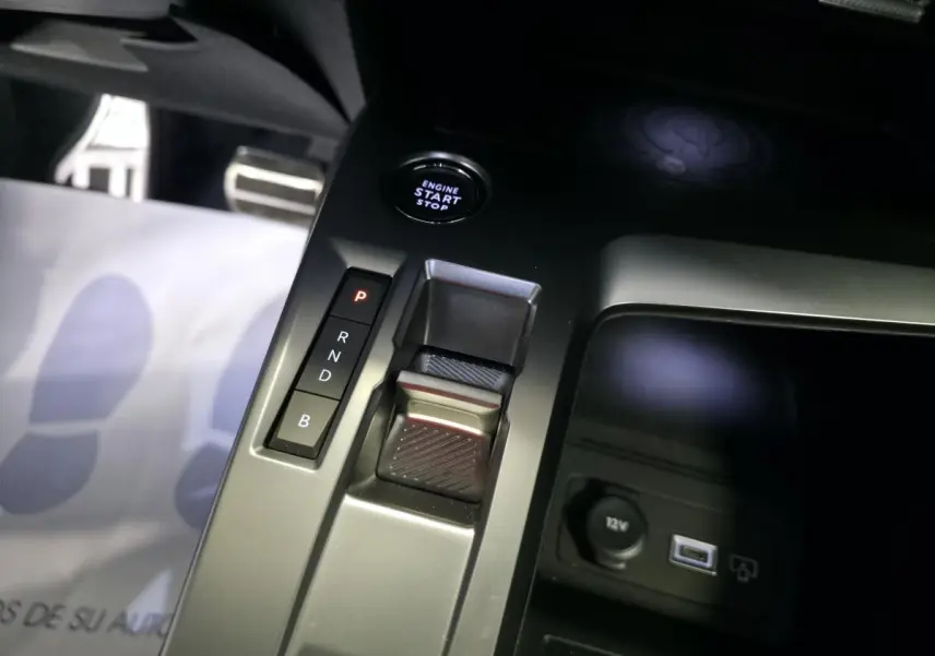 Gros plan sur la console centrale du Peugeot 408 gris, avec sélecteur de boîte auto, bouton start/stop et prise 12V visible.