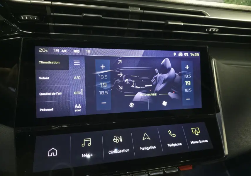 Écran tactile central affichant la climatisation et les réglages du volant dans l'habitacle noir du Peugeot 408 gris