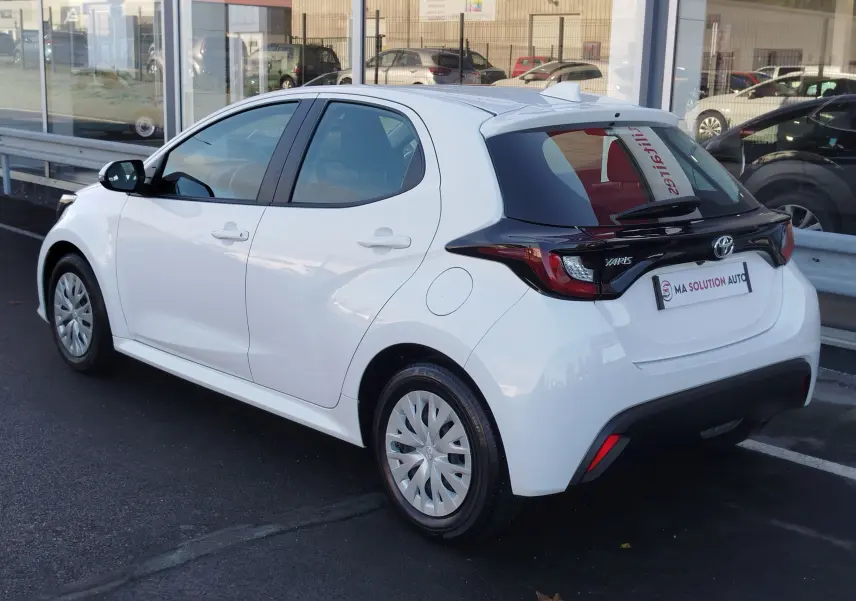Toyota Yaris blanc pur vue 3/4 arrière droit, avec toit noir contrasté et feux arrière LED distinctifs.