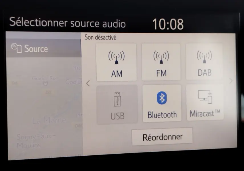 Écran tactile intérieur de la Toyota Yaris blanc pur 2023 affichant les options audio avec Bluetooth sélectionné.