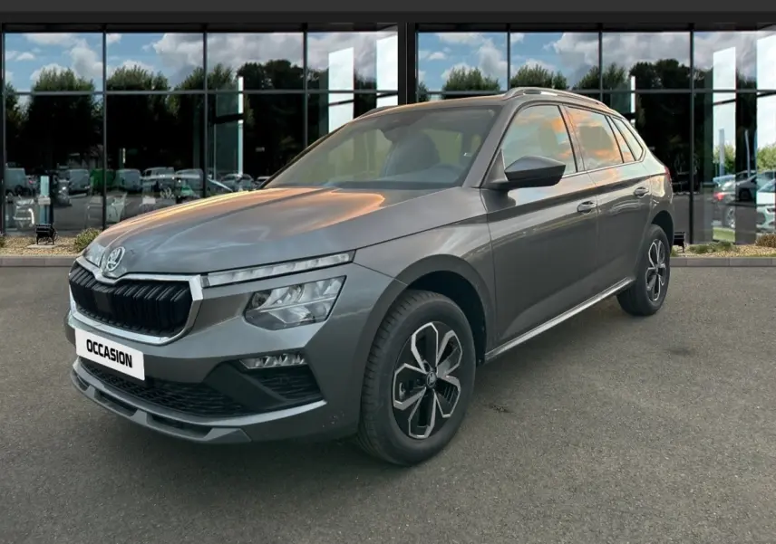 Vue 3/4 avant d'un Skoda Kamiq gris clair 2025 avec calandre noire et jantes au design moderne.