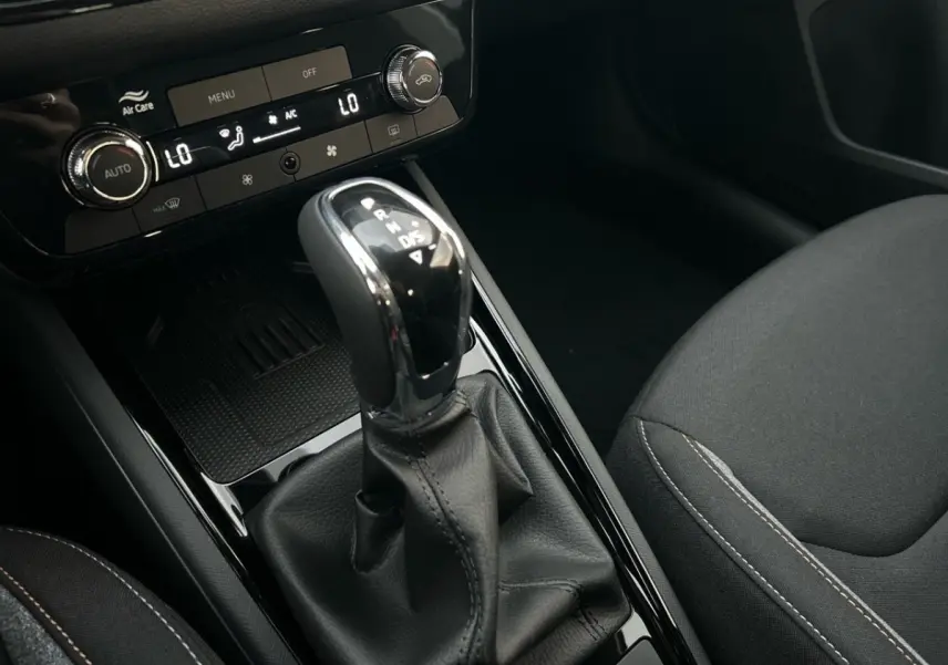 Le levier de vitesse automatique noir et chrome du Skoda Kamiq 2025, avec console centrale et siège tissu gris visible.