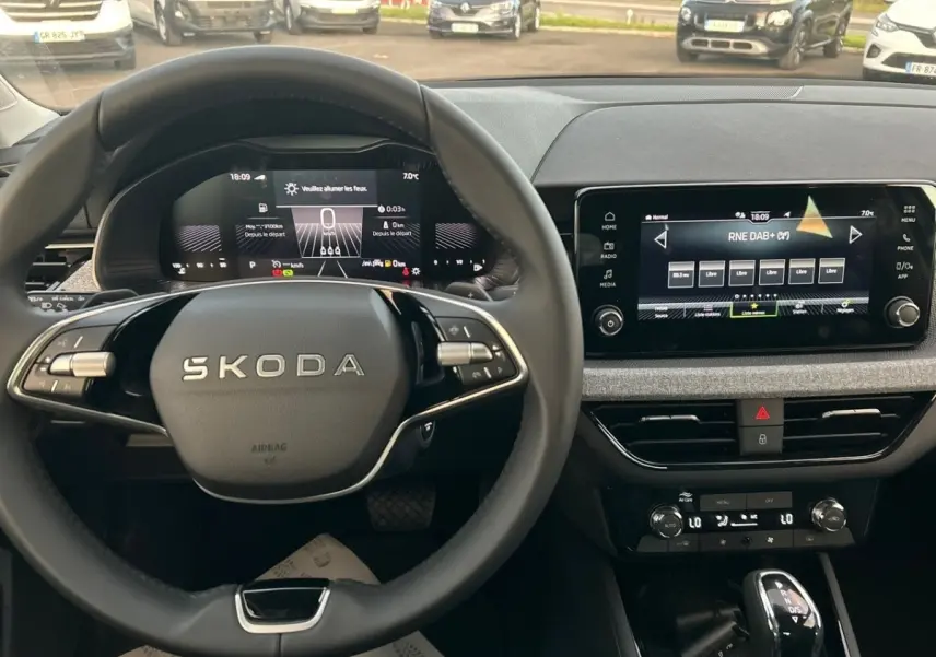 Vue intérieure du tableau de bord et volant Skoda Kamiq gris clair 2025 avec écran tactile et combiné numérique.
