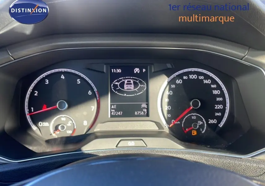 Vue rapprochée du tableau de bord du Volkswagen T-Roc 1.5 TSI bleu Ravenna, affichant compteurs et écran central numérique.