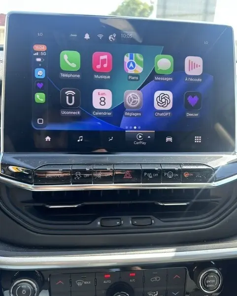 Écran tactile central du Jeep Compass 2025 montrant interface Apple CarPlay avec commandes climatisation et multimédia en dessous.