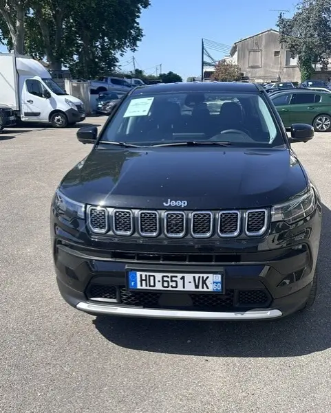 Vue de face d'un Jeep Compass noir 2025 avec calandre à sept fentes et plaques d'immatriculation françaises visibles.