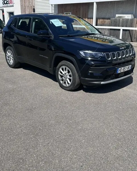 Jeep Compass noir en vue 3/4 avant droit, avec jantes alliage 18 pouces et calandre distinctive à sept fentes.