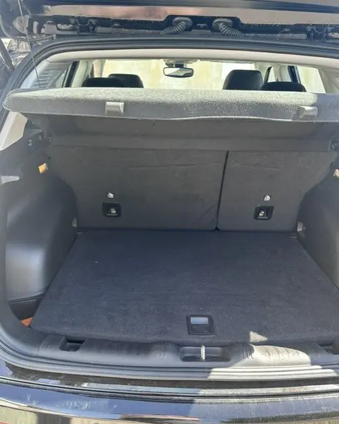 Coffre ouvert en vue arrière d’un Jeep Compass noir 2025, montrant un espace de chargement propre avec cache-bagages relevé.