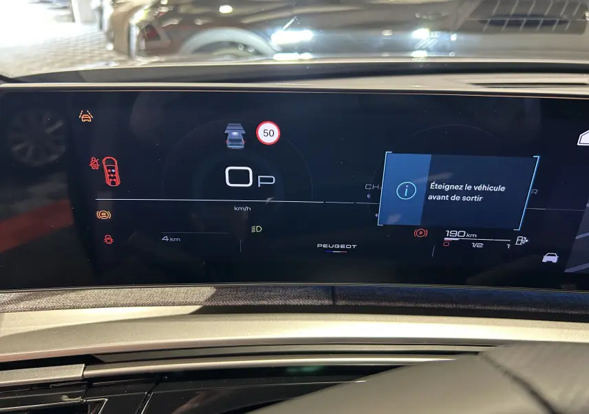 Tableau de bord numérique du Peugeot 5008 III GT Hybrid 145, affichant la vitesse à 0 km/h et alertes actives.