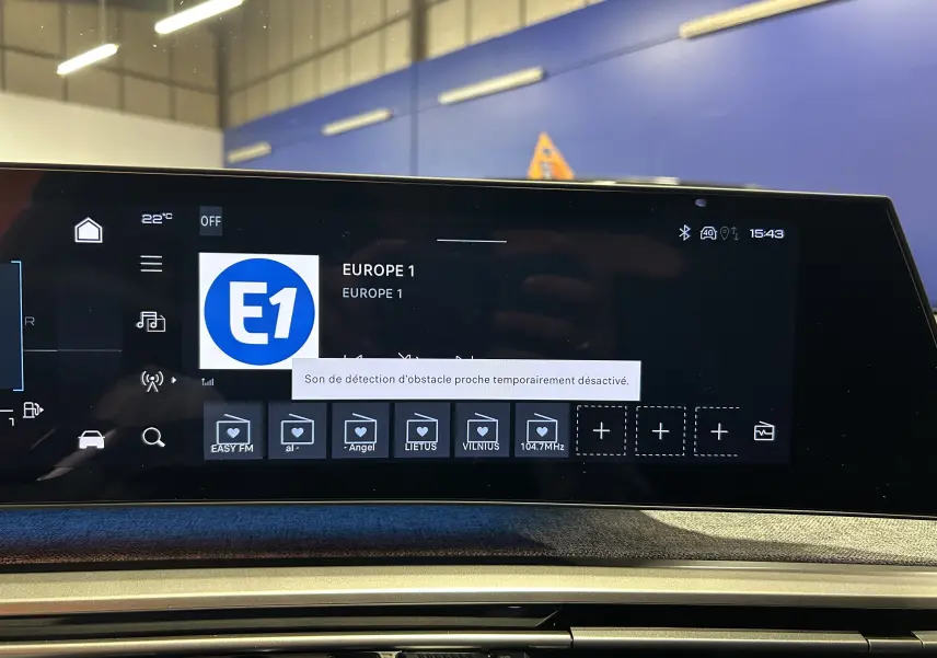 Écran tactile central du tableau de bord du Peugeot 5008 III GT Hybrid 145, affichant la radio Europe 1.