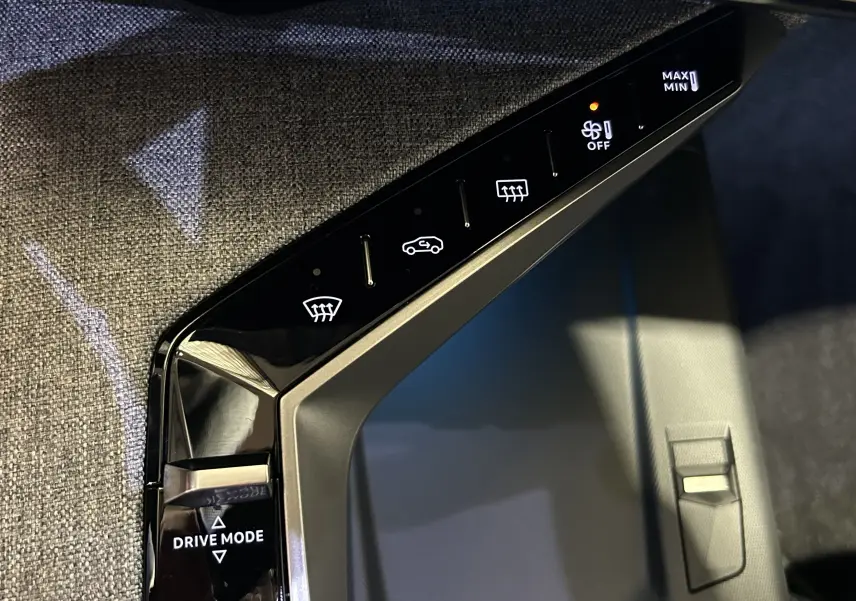 Gros plan sur la console centrale du Peugeot 5008 gris Artense, avec commandes tactiles de climatisation et mode de conduite.