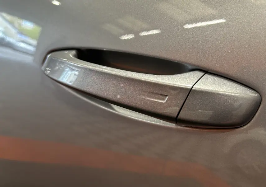 Poignée de porte gris Artense en gros plan sur Peugeot 5008 III GT Hybrid 145 e-DCS6, finition métallisée biton.