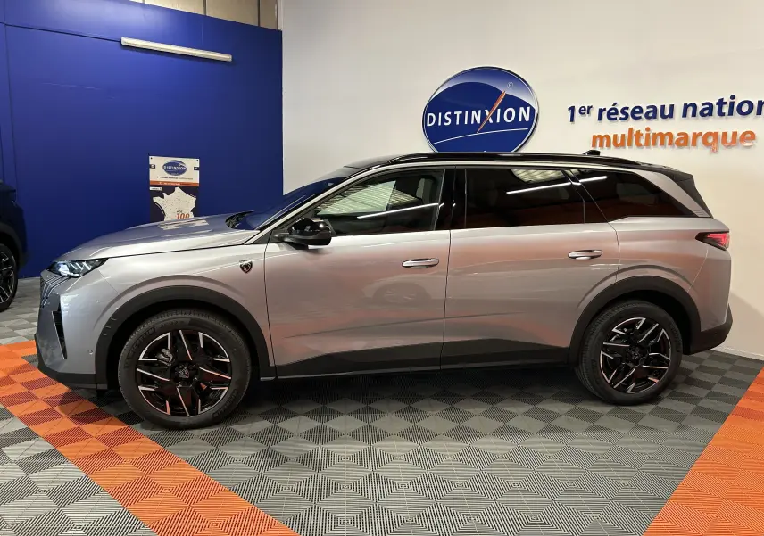 Peugeot 5008 III GT Hybrid gris Artense vu de profil côté gauche, avec jantes noires et toit noir biton.