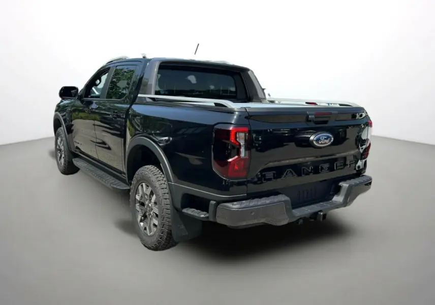 Ford Ranger 2025 noir agate en vue 3/4 arrière droit, pick-up hybride avec logo Ford et feux arrière LED distinctifs.