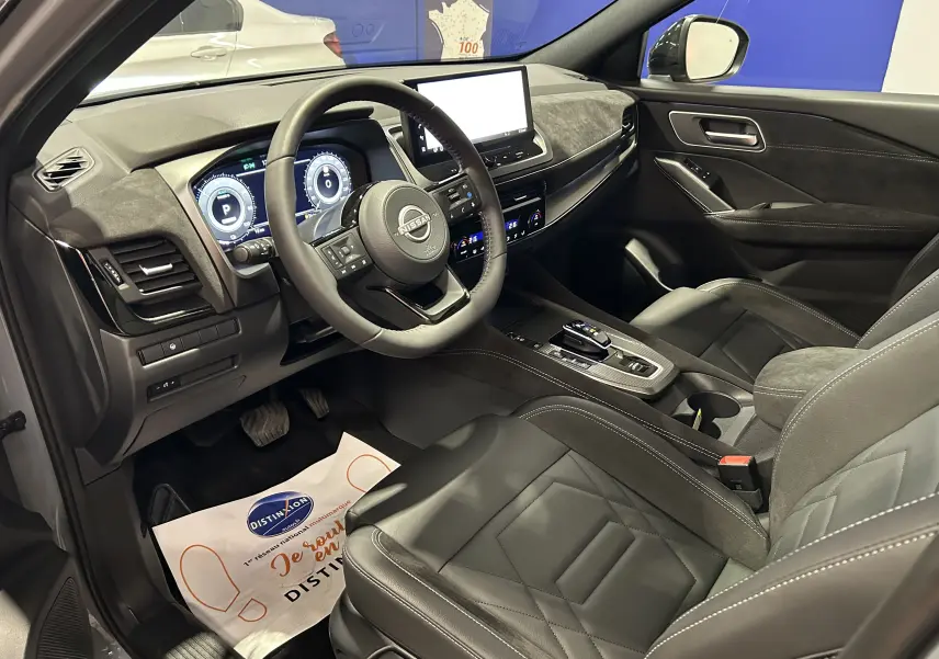 Intérieur du Nissan Qashqai 2025 vu côté conducteur, avec sièges cuir noir et tableau de bord moderne.