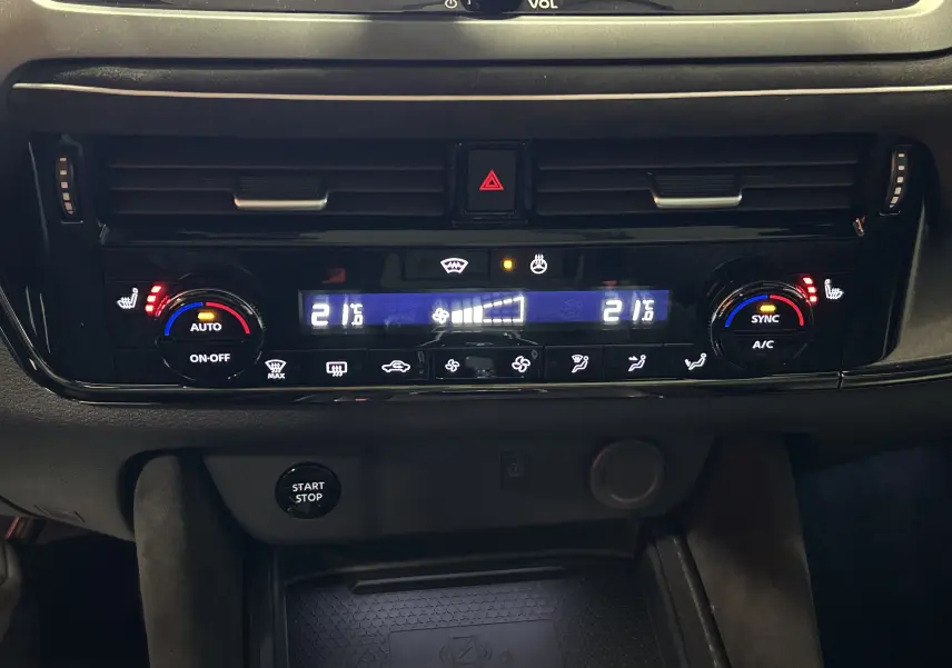 Tableau de bord du Nissan Qashqai 2025 montrant la climatisation automatique avec affichage digital et commandes tactiles.