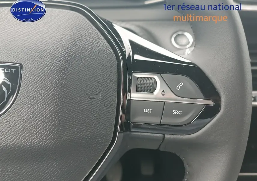 Gros plan sur le volant multifonction noir du Peugeot 2008 1.2 100 Allure avec commandes audio intégrées.