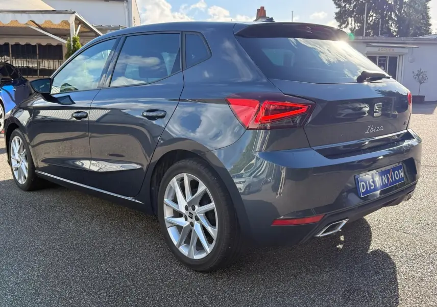Vue 3/4 arrière droite d'une SEAT Ibiza 2025 gris foncé avec feux LED et jantes alliage distinctives.