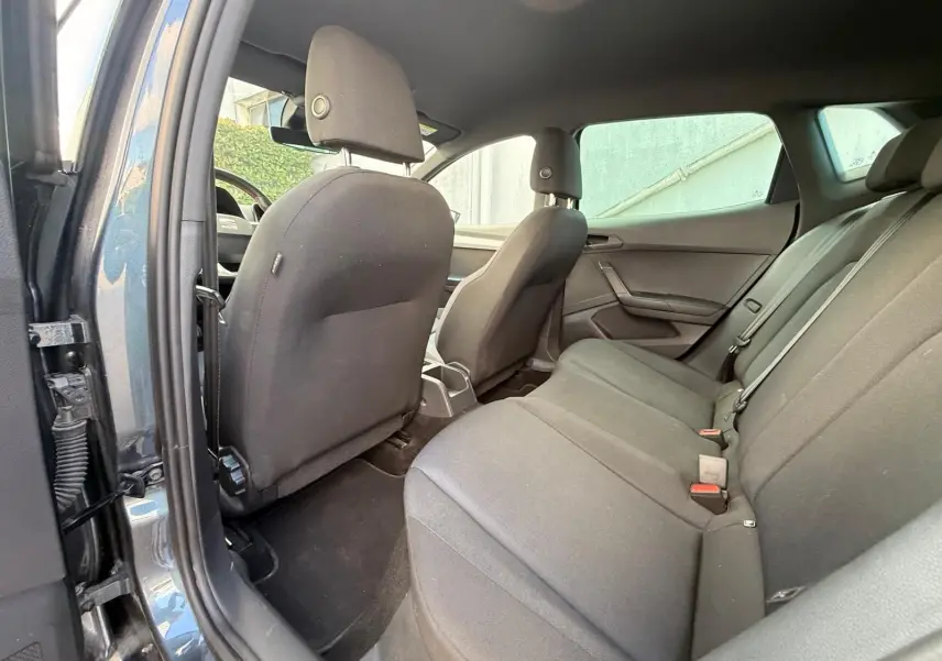 Vue intérieure du siège arrière côté droit d'une SEAT Ibiza 1.0 TSI 95 FR gris foncé avec sellerie tissu noire.