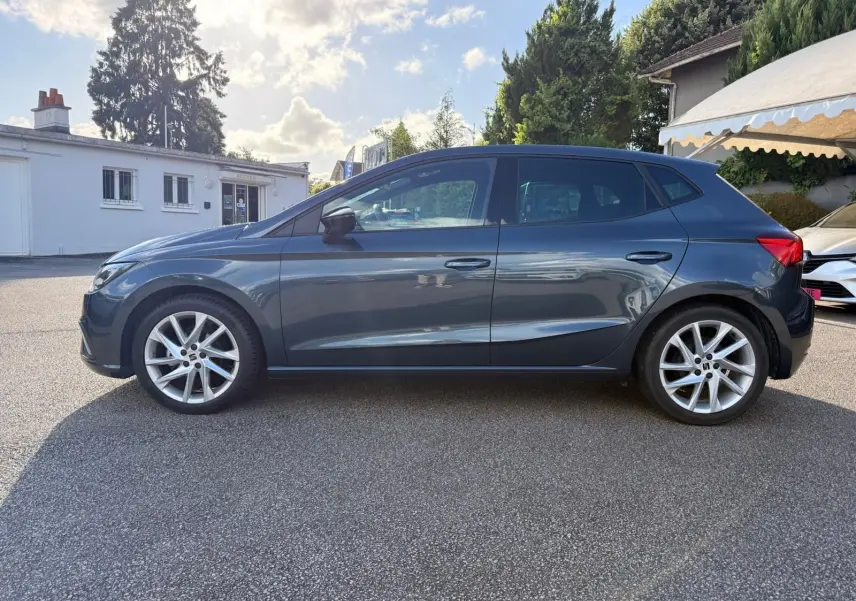 Vue de profil côté gauche d'une SEAT Ibiza 1.0 TSI 95 FR gris foncé 2025 avec jantes alliage et lignes dynamiques.