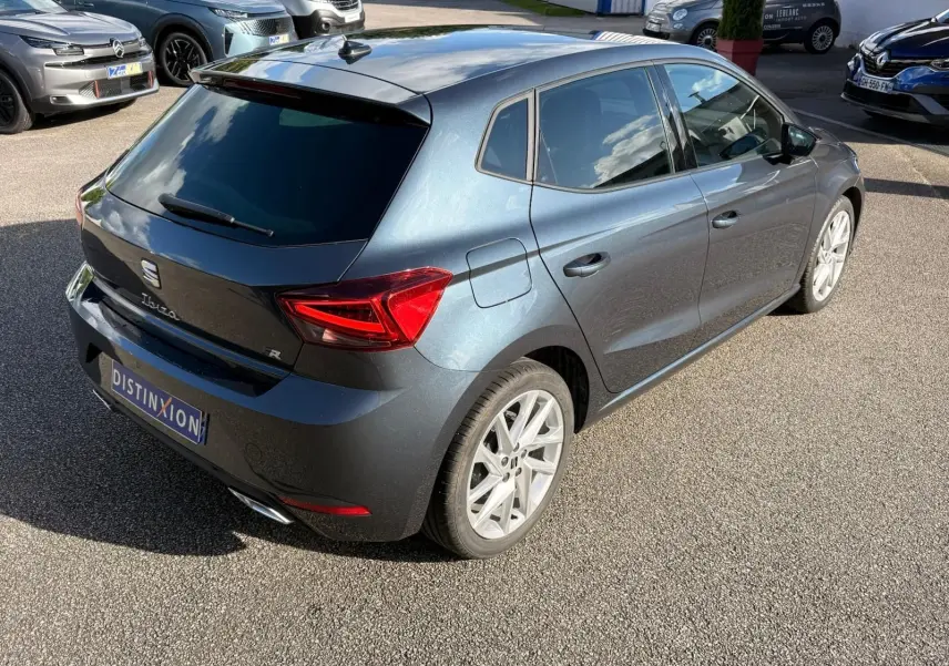 Vue 3/4 arrière droit d'une SEAT Ibiza 1.0 TSI 95 FR gris foncé avec jantes alliage et feux LED distinctifs.