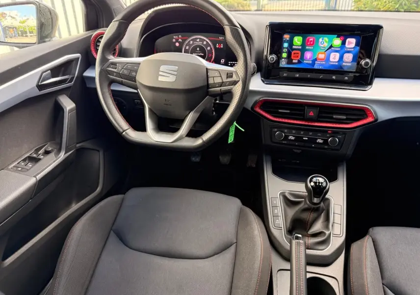 Intérieur de la SEAT Ibiza 1.0 TSI 95 FR 2025, vue du poste de conduite avec volant multifonction et écran tactile central.