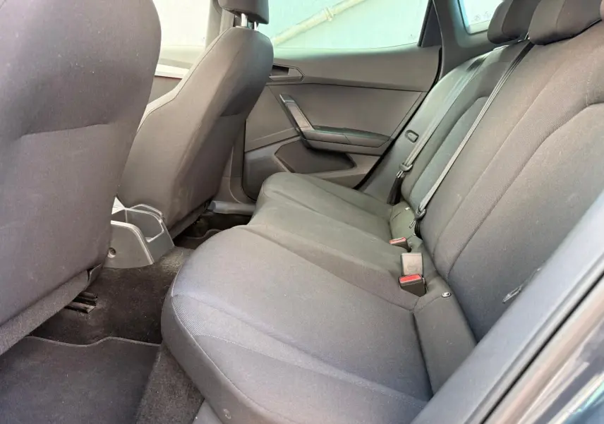 Vue intérieure côté droit des sièges arrière gris foncé d'une SEAT IBIZA 1.0 TSI 95 FR 2025, tissu sobre et ceintures visibles.