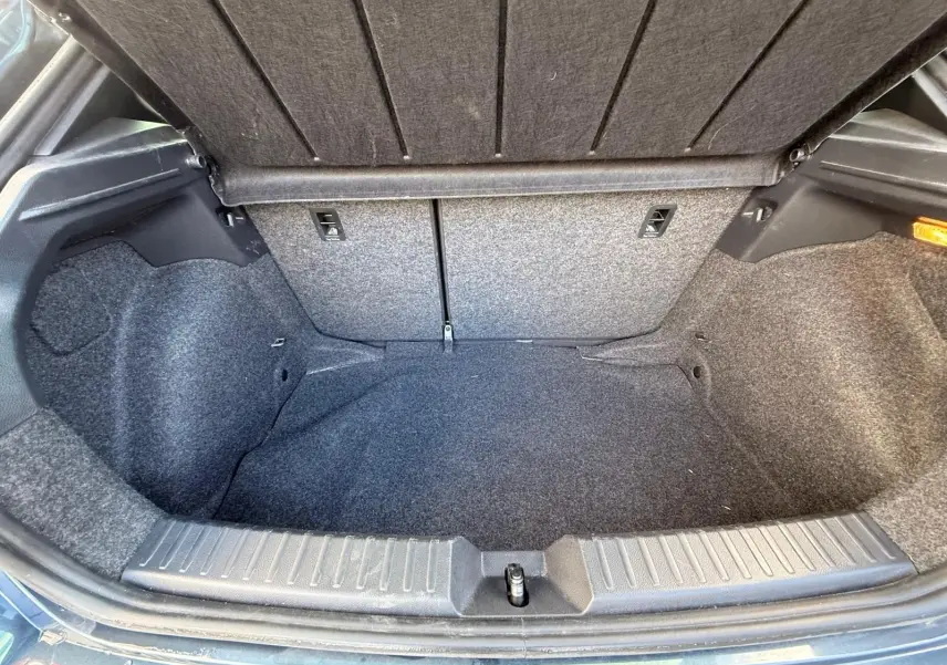 Coffre ouvert de la SEAT Ibiza 1.0 TSI 95 FR gris foncé, vue intérieure montrant l'espace de rangement vide.