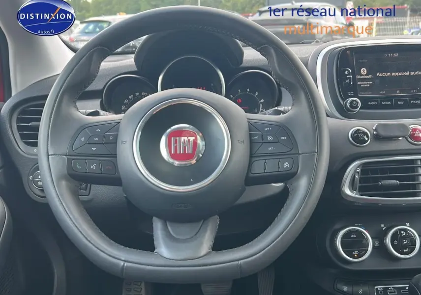 Vue centrée sur le volant cuir multifonction FIAT 500X 2016 avec tableau de bord et écran tactile visible.