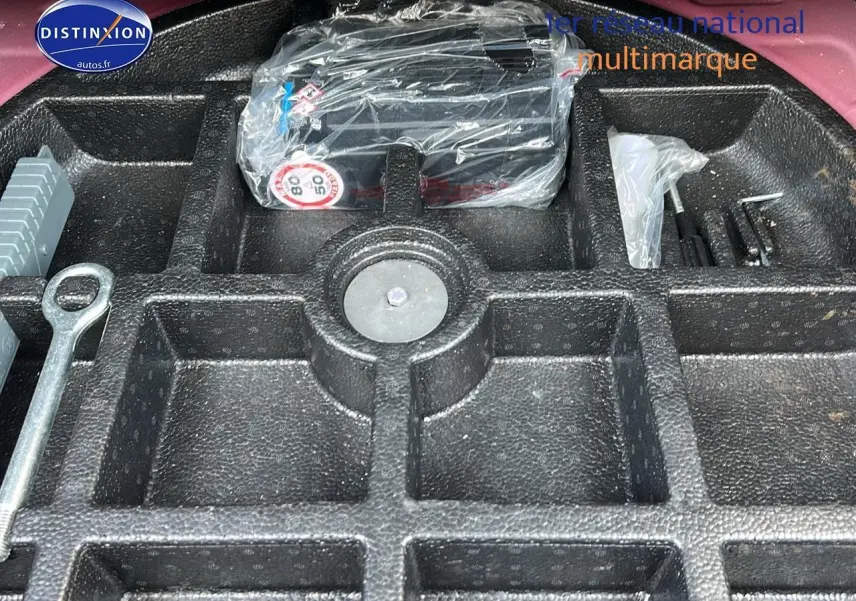 Coffre ouvert d'une Fiat 500X rouge montrant le rangement en mousse pour outils et kit anti-crevaison.