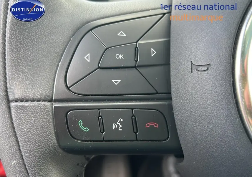 Gros plan sur les commandes au volant cuir multifonction de la FIAT 500X rouge, version 2016 cross.